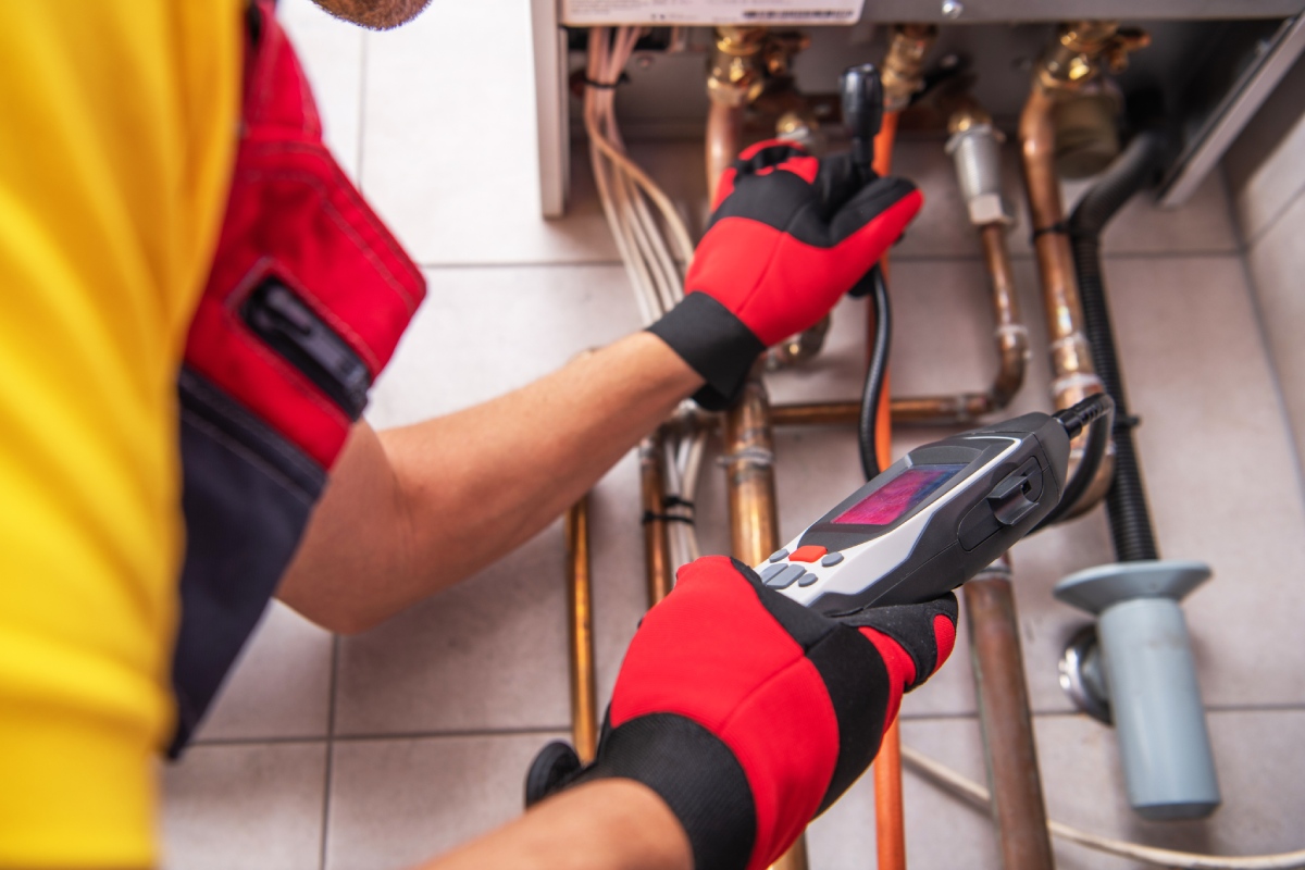 Technicien contrôlant une installation de gaz avec un appareil de mesure